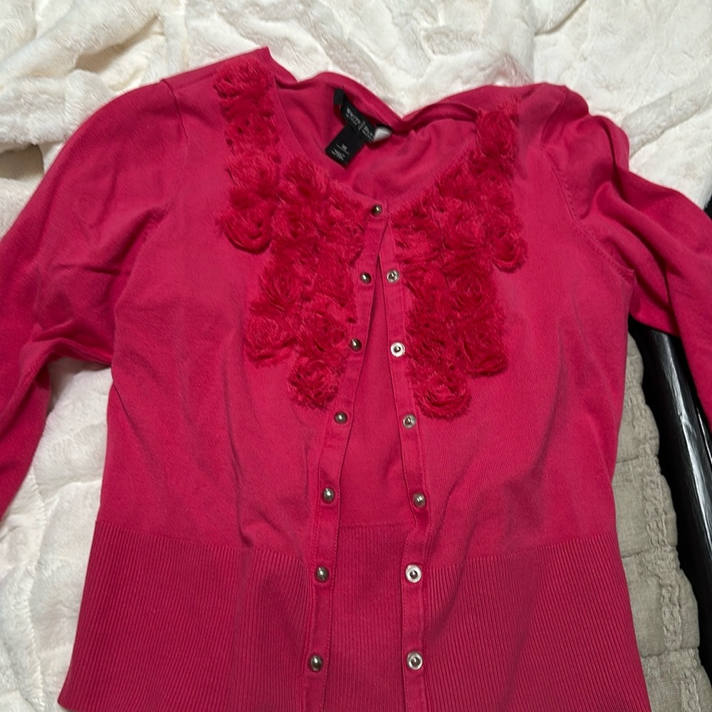 Hot pink cardigan with floral detail.